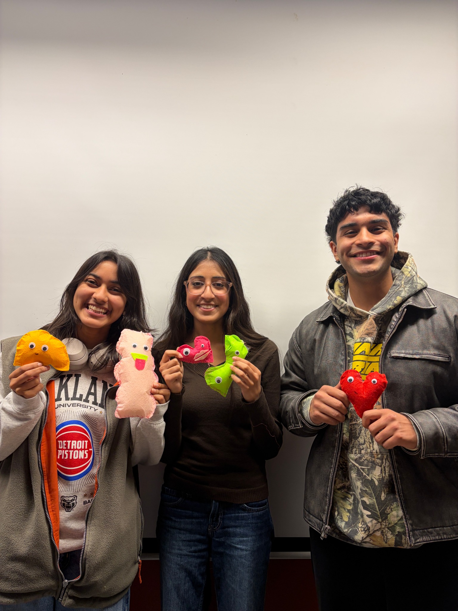 Three OTHA members holding handmade organ plushies